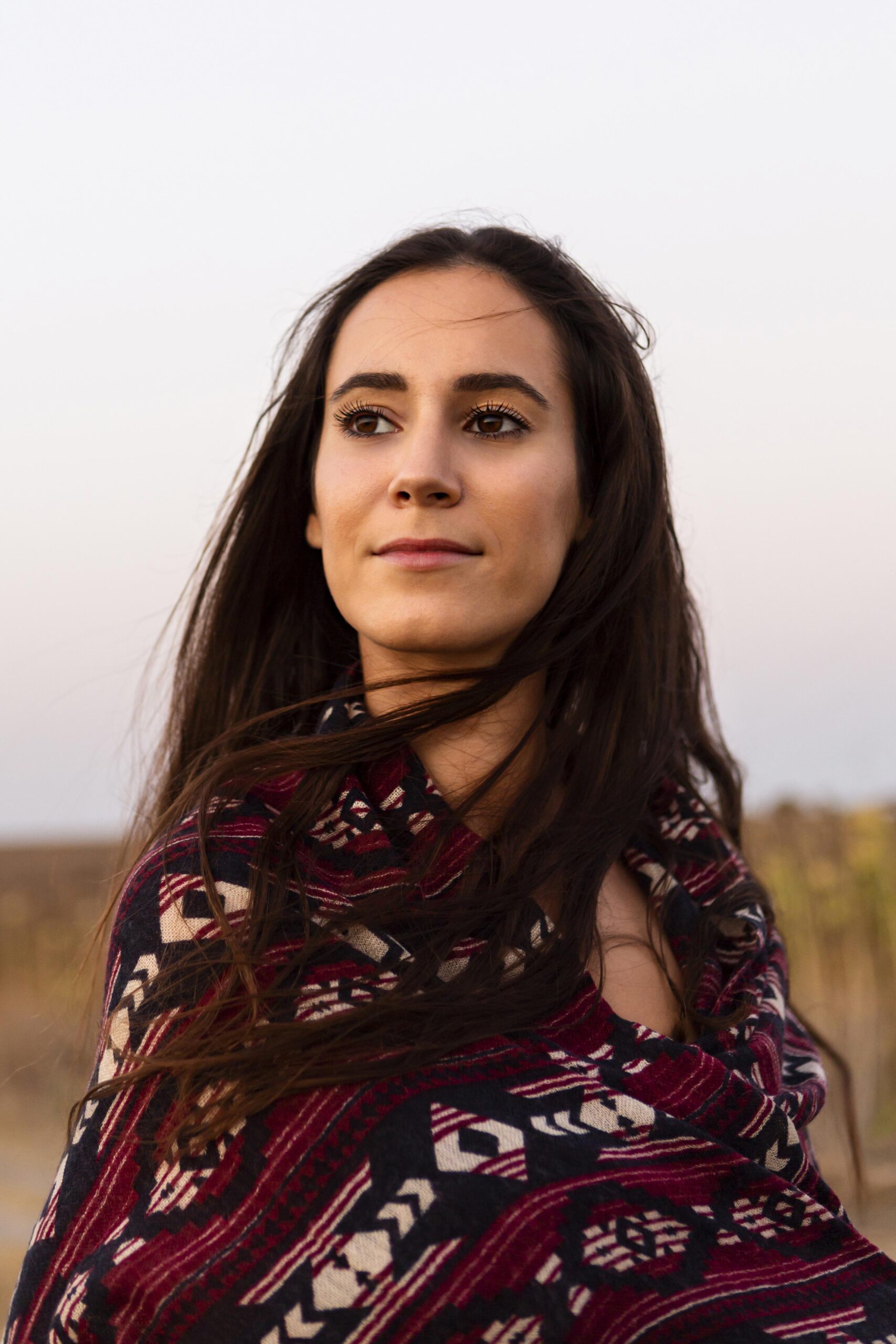 beautiful-woman-posing-outdoors-with-blanket-scaled